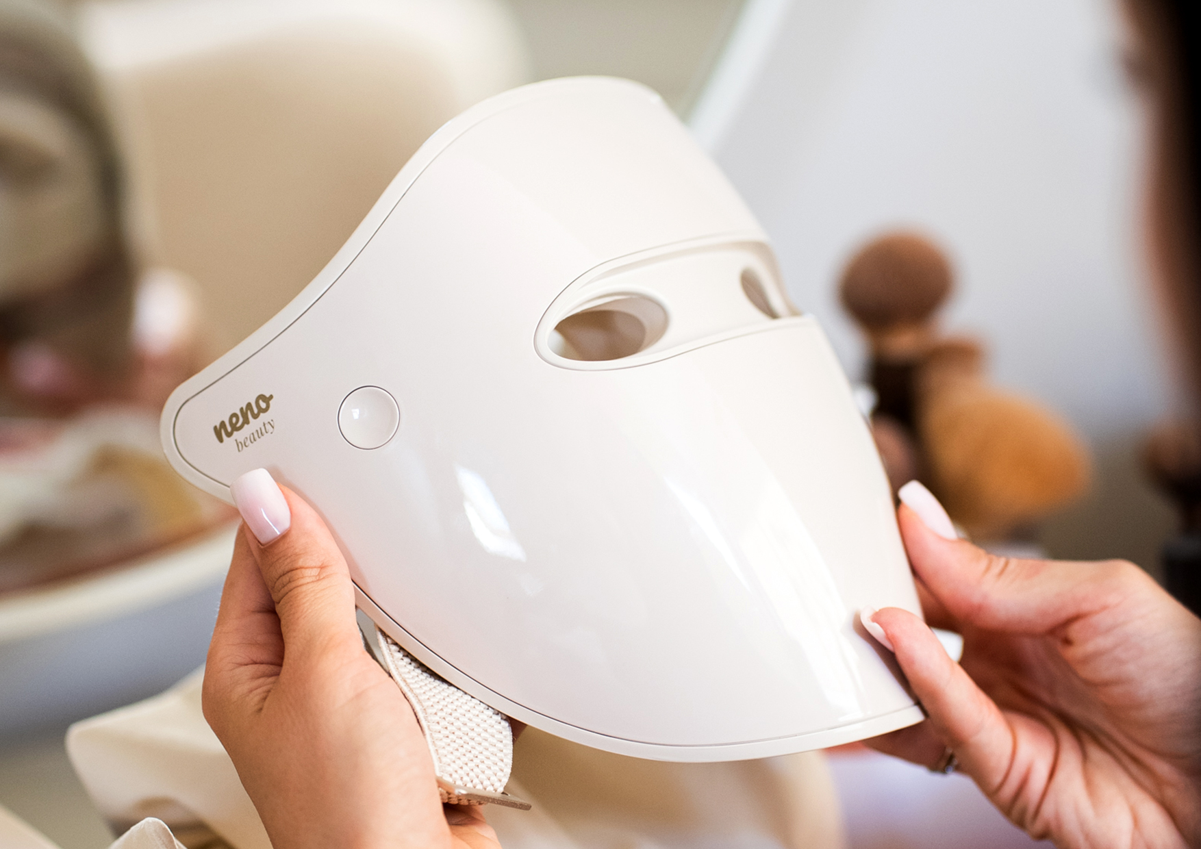 Kobieta trzyma maskę Neno Beauty Alva w dłoniach. Tekst o zasadach bezpieczeństwa: czysta skóra, unikanie fotouczulenia, przerwy po kuracjach, nieużywanie w ciąży, zachowanie czasu sesji.