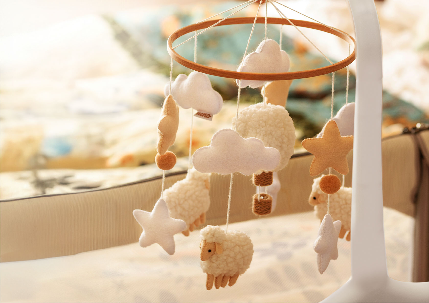 Karuzela Neno Nelu z barankami i chmurkami w beżowych odcieniach. Delikatny ruch zawieszek wprowadza harmonię do pokoju dziecka.
