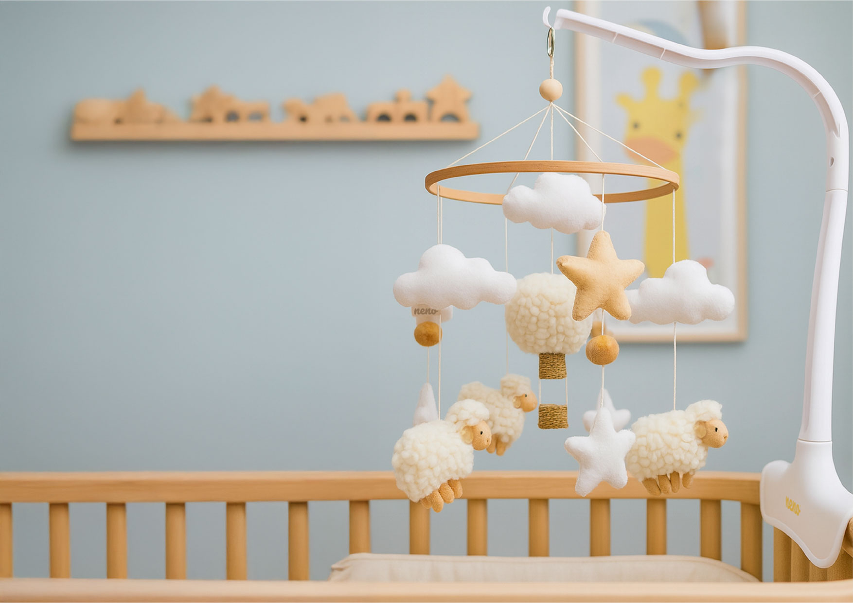 Karuzela Neno Nelu zamocowana nad łóżeczkiem. Drewniany pierścień z barankami i chmurkami pokazuje prosty montaż.