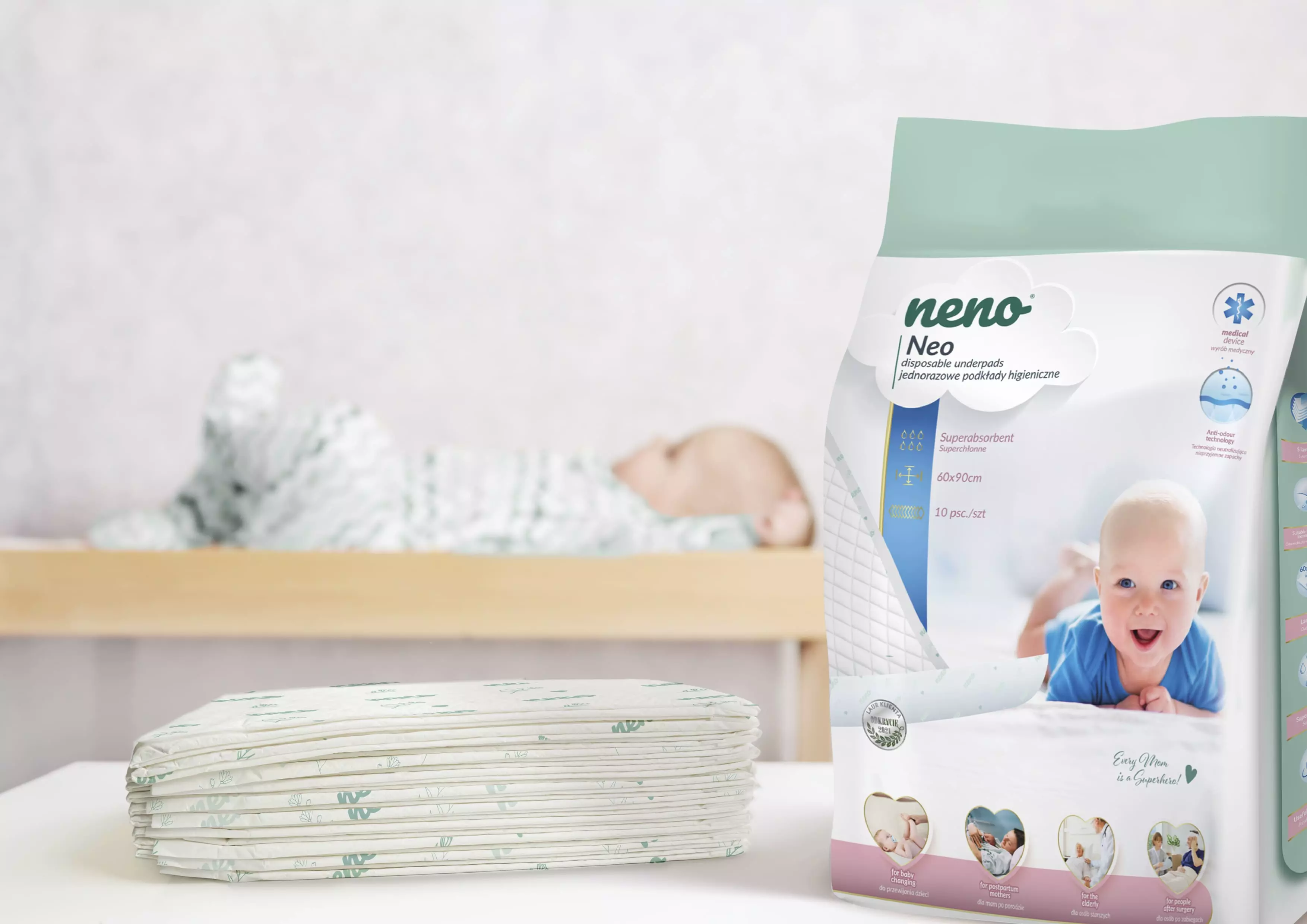 package of disposable sanitary pads on the table and next to it a baby in a crib