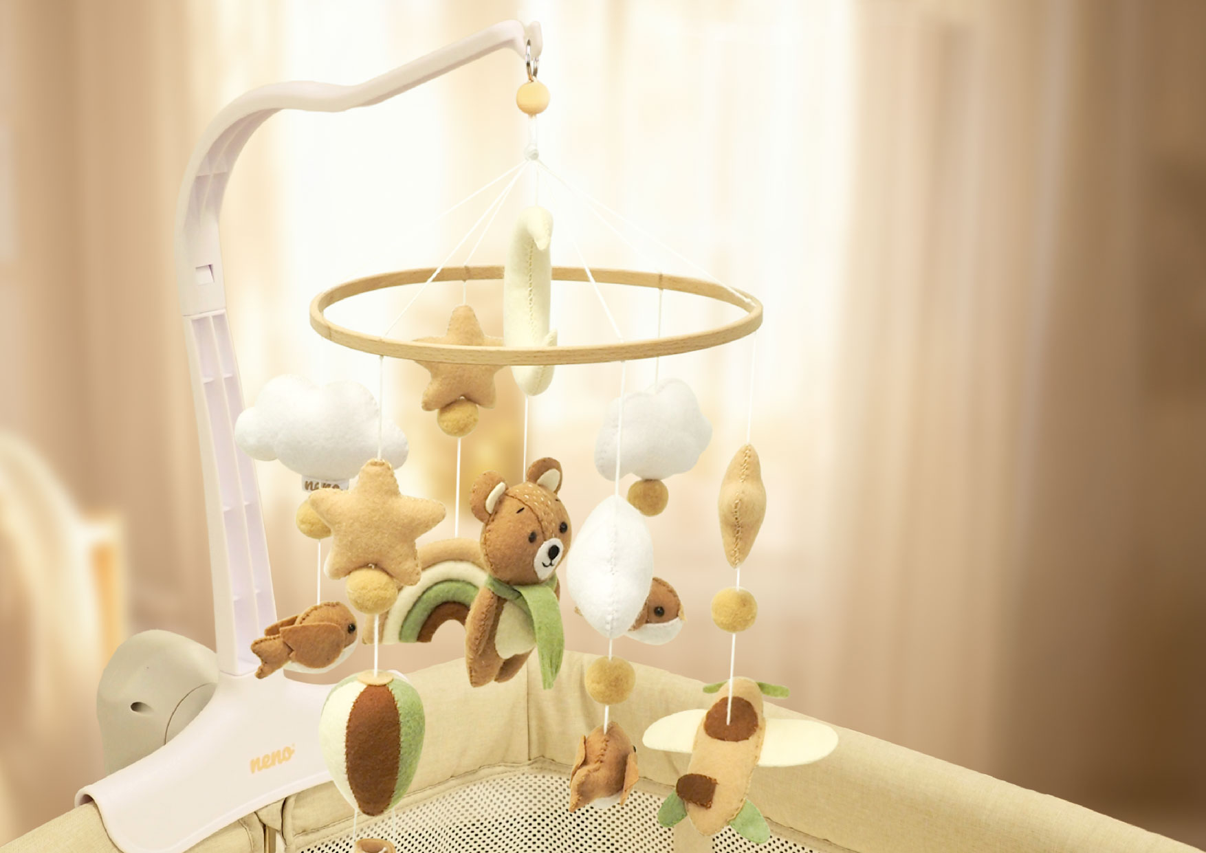 Karuzela Neno Pico zamocowana nad łóżeczkiem. Drewniany pierścień z zawieszkami w kształcie misiów, gwiazdek i chmurek.