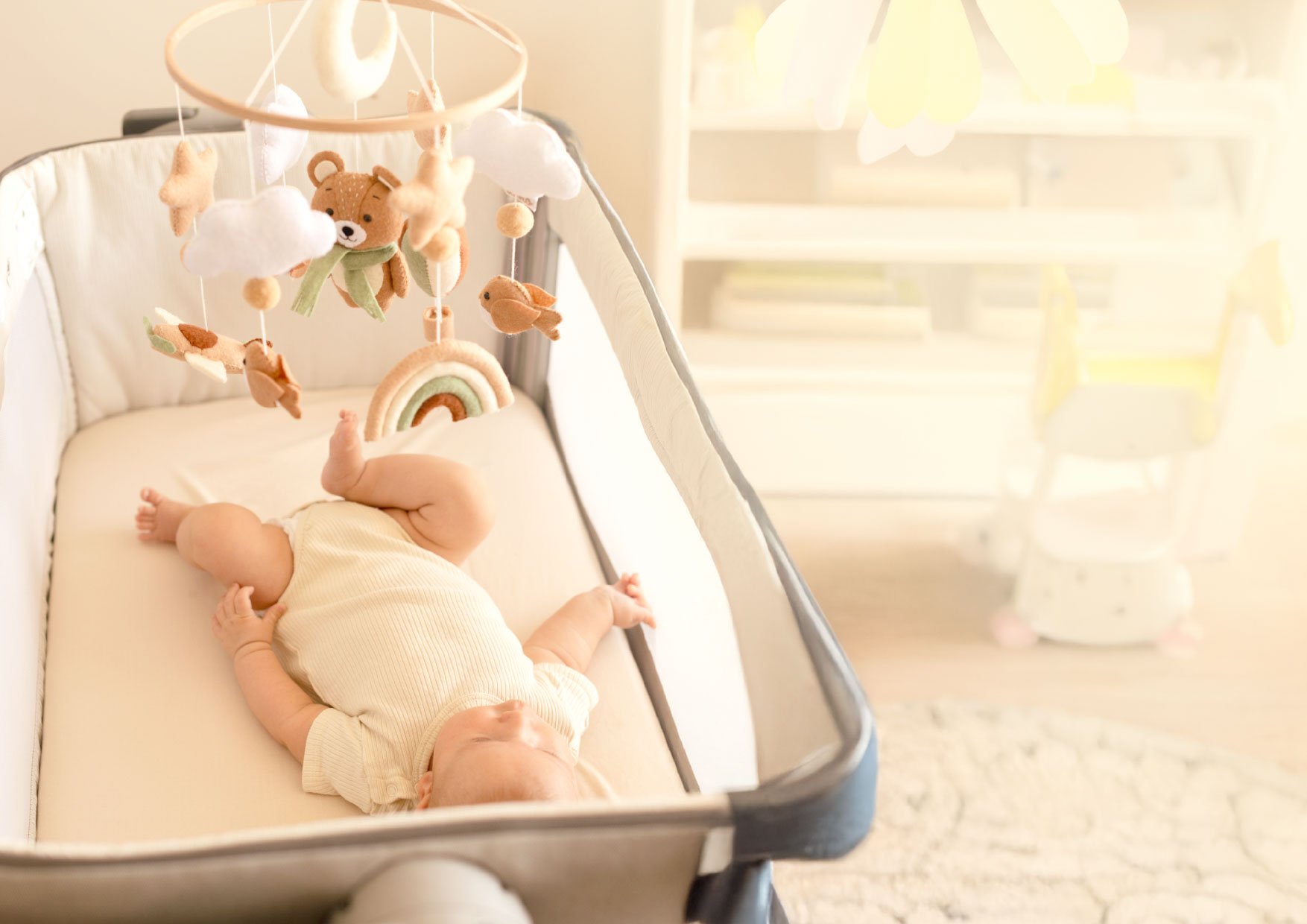 Dziecko patrzy na karuzelę Neno Pico z misiami i gwiazdkami. Poruszające się zawieszki stymulują wzrok i koncentrację.