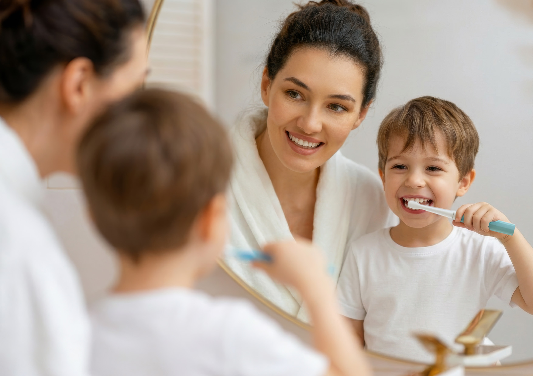 Szczoteczka elektryczna dla dzieci trzymana w dłoni, widok podświetlonego przycisku