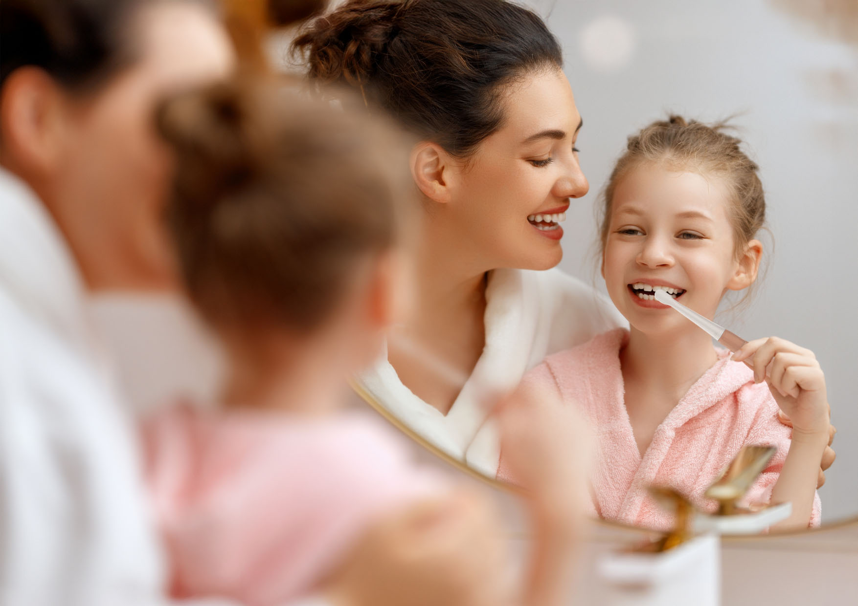 Szczoteczka elektryczna dla dzieci trzymana w dłoni, widok podświetlonego przycisku